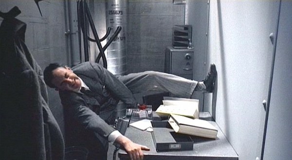 screenshot from the film Brazil of a man fighting over a desk in a tiny office space