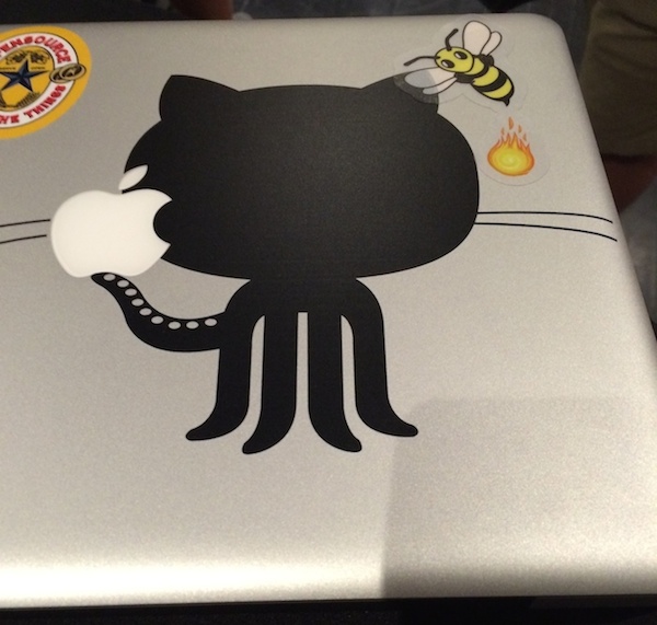 photo of a mac laptop with a github octocat sticker and a firebee sticker attacking the octocat with fire