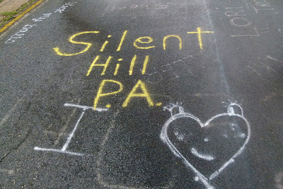Graffiti on a road with the words Silent Hill.